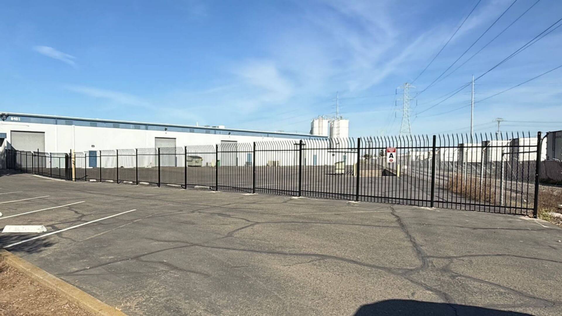 Commercial ornamental iron fence installation at industrial warehouse property in Sacramento CA