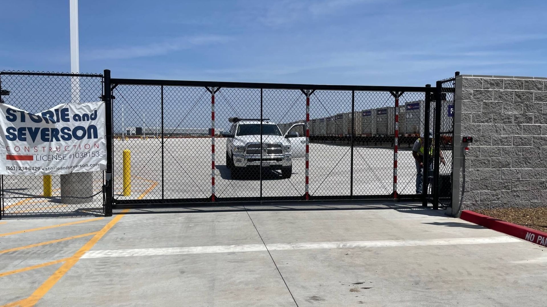 Commercial black chain link sliding security gate installed at FedEx facility