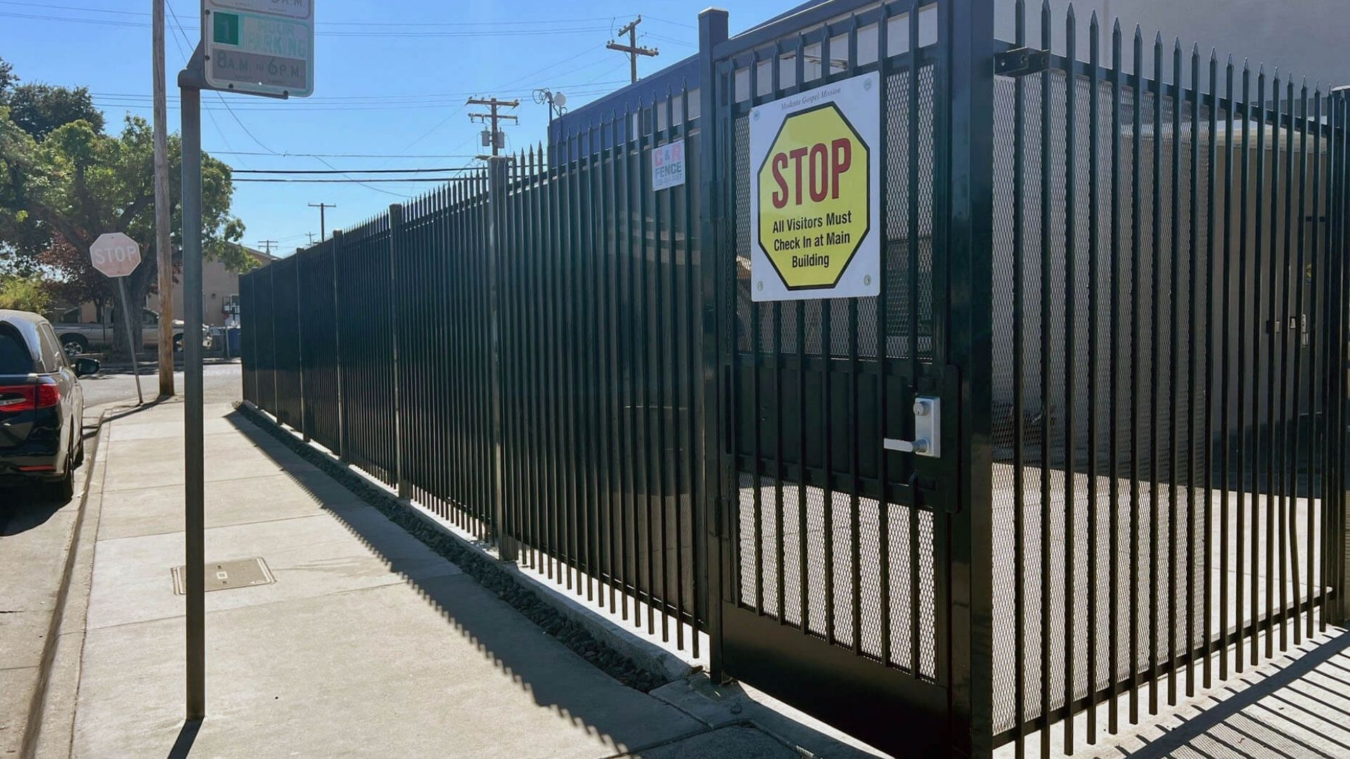 Black iron security fence and pedestrian entrance at Modesto Gospel Mission