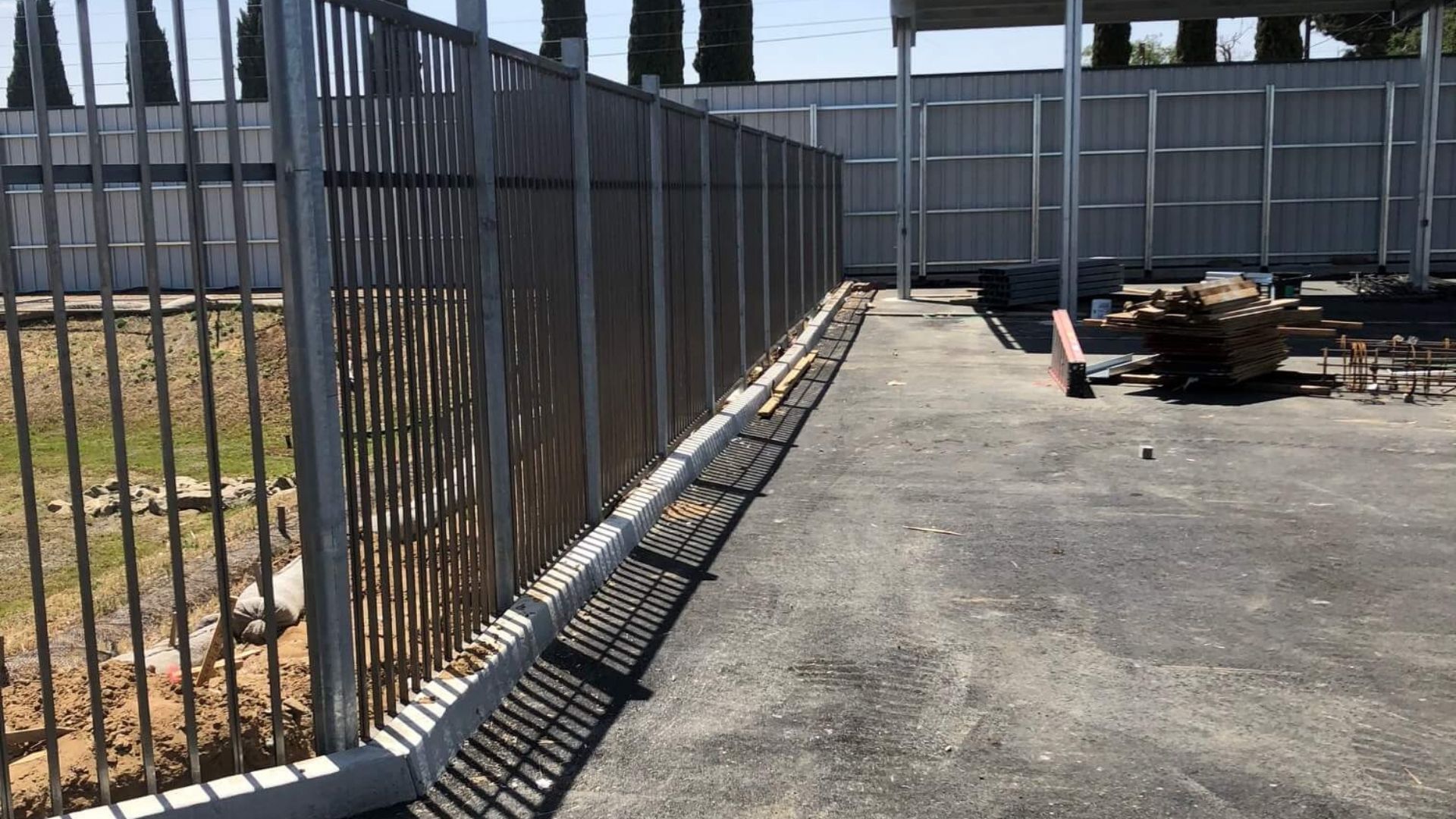 Long perimeter ornamental iron fence surrounding RV storage yard in Antioch